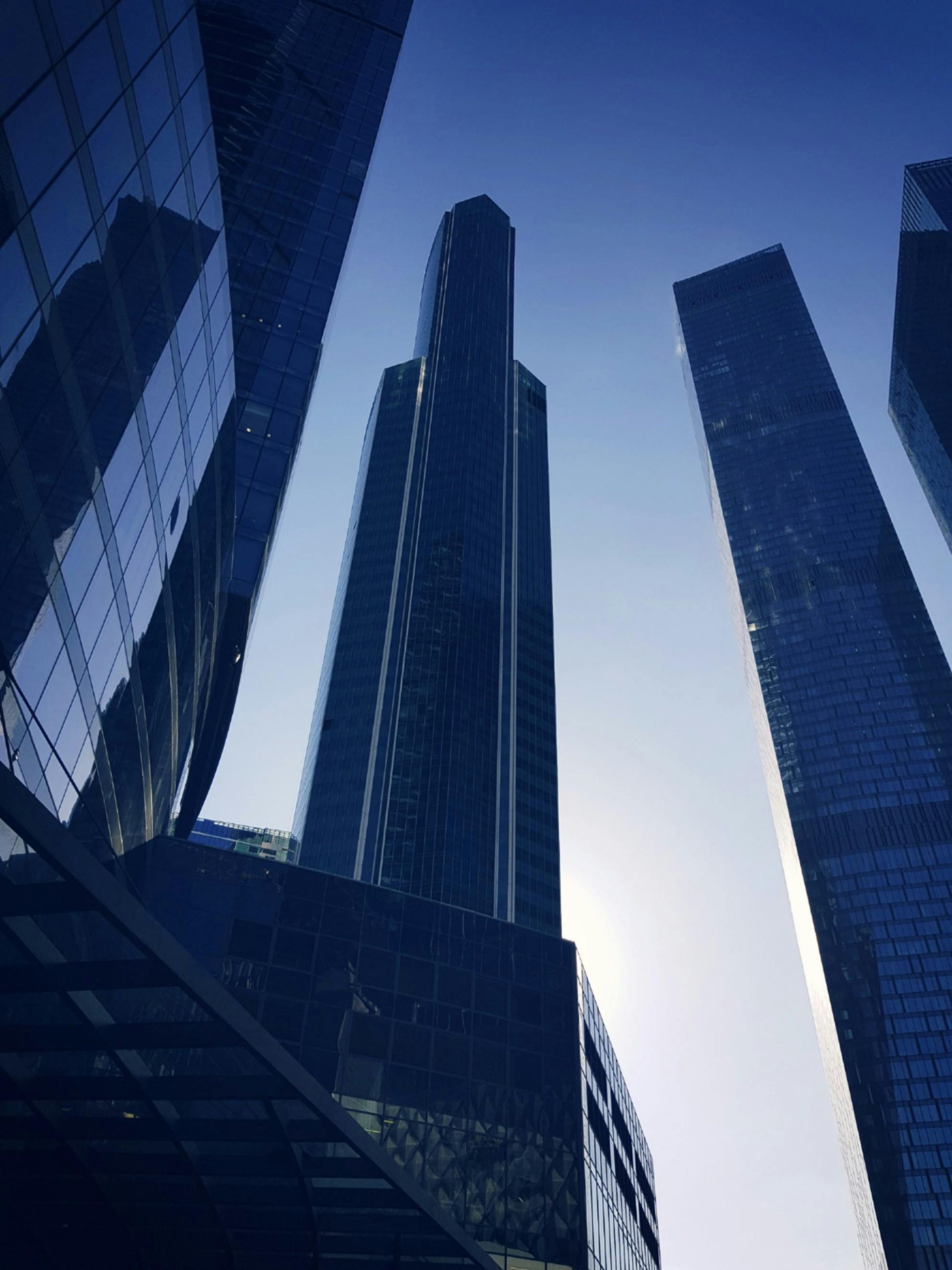 Low angle view of modern skyscrapers in Moscow with a striking morning sun backdrop.